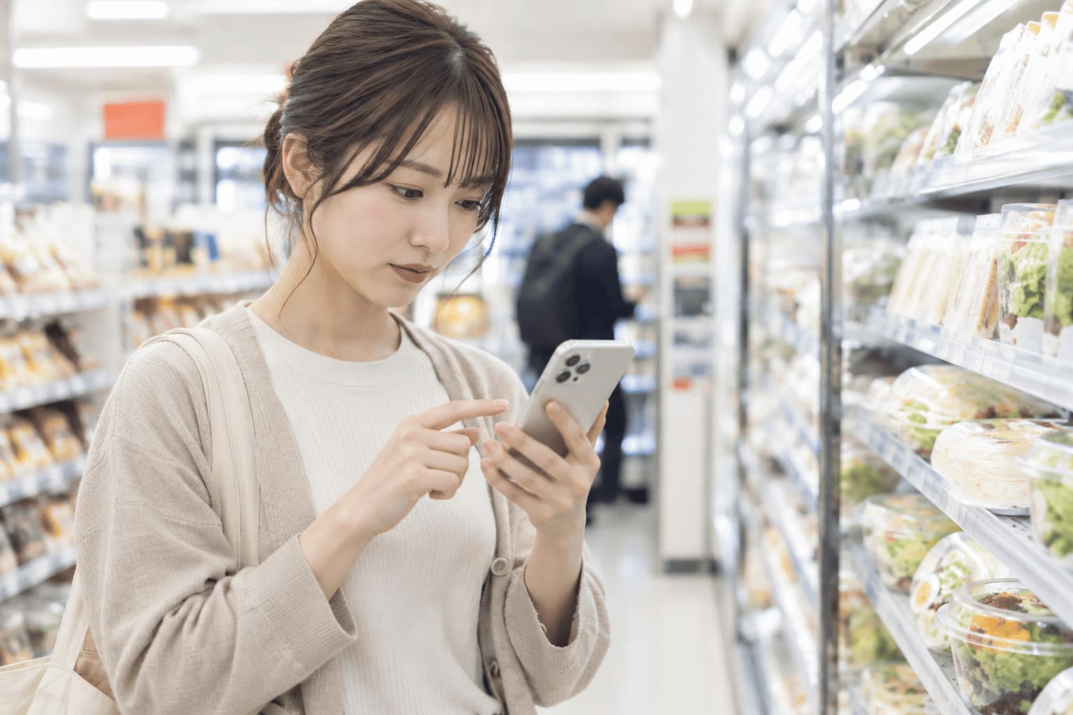 スマートフォンで店舗の取り扱い情報を確認している様子