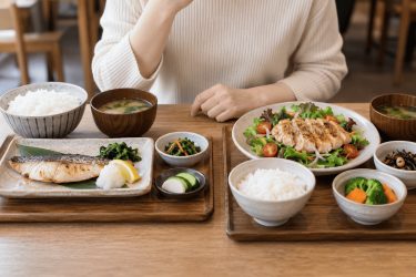 外食で魚料理と鶏肉料理の定食を選ぶ場面のイメージ